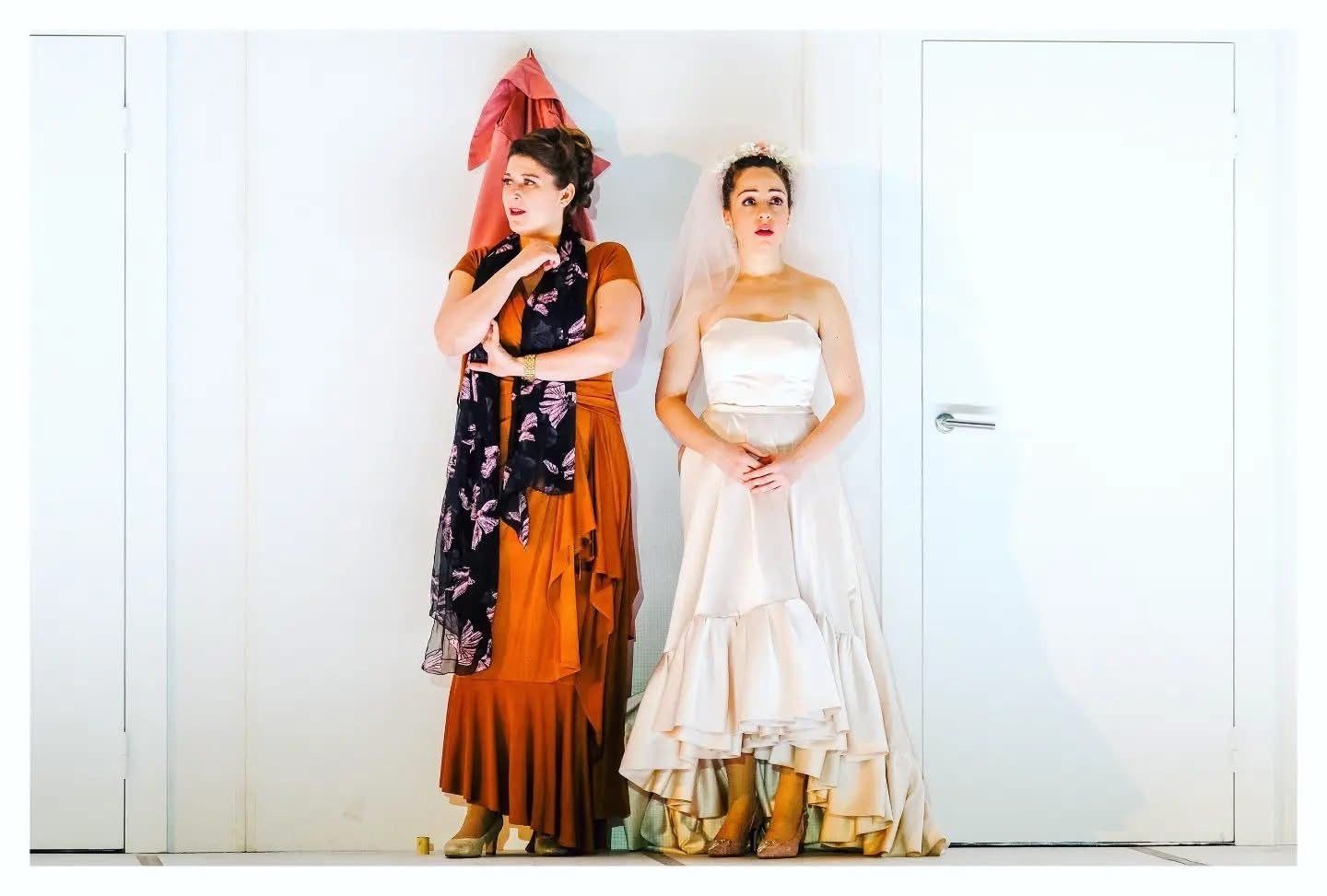 In a bridal gown and veil beside a colleague in rust