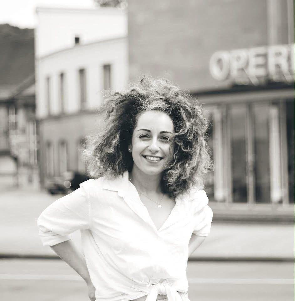 Portrait of Ralitsa Ralinova smiling, with her curly hair loose