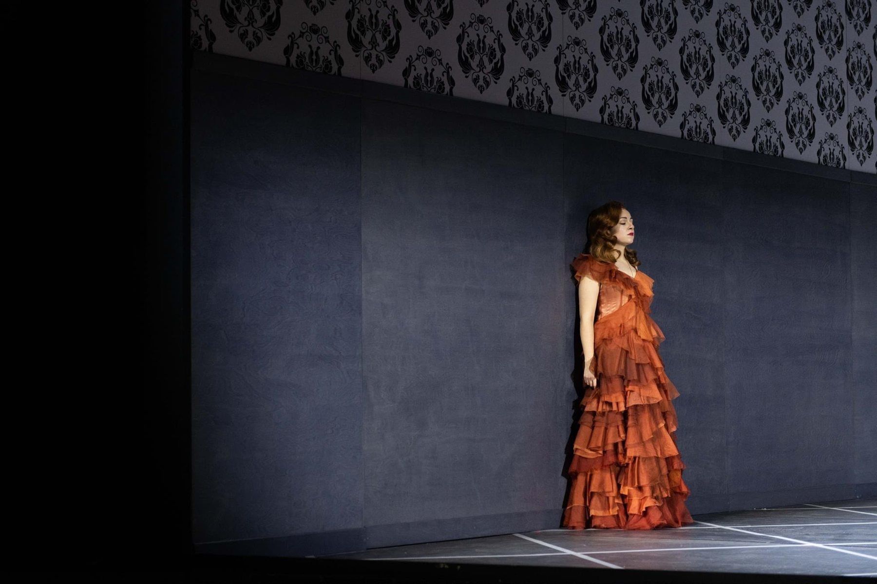 Ralitsa Ralinova on stage in a rust ruffled gown